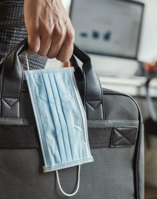 man with a briefcase and a surgical mask